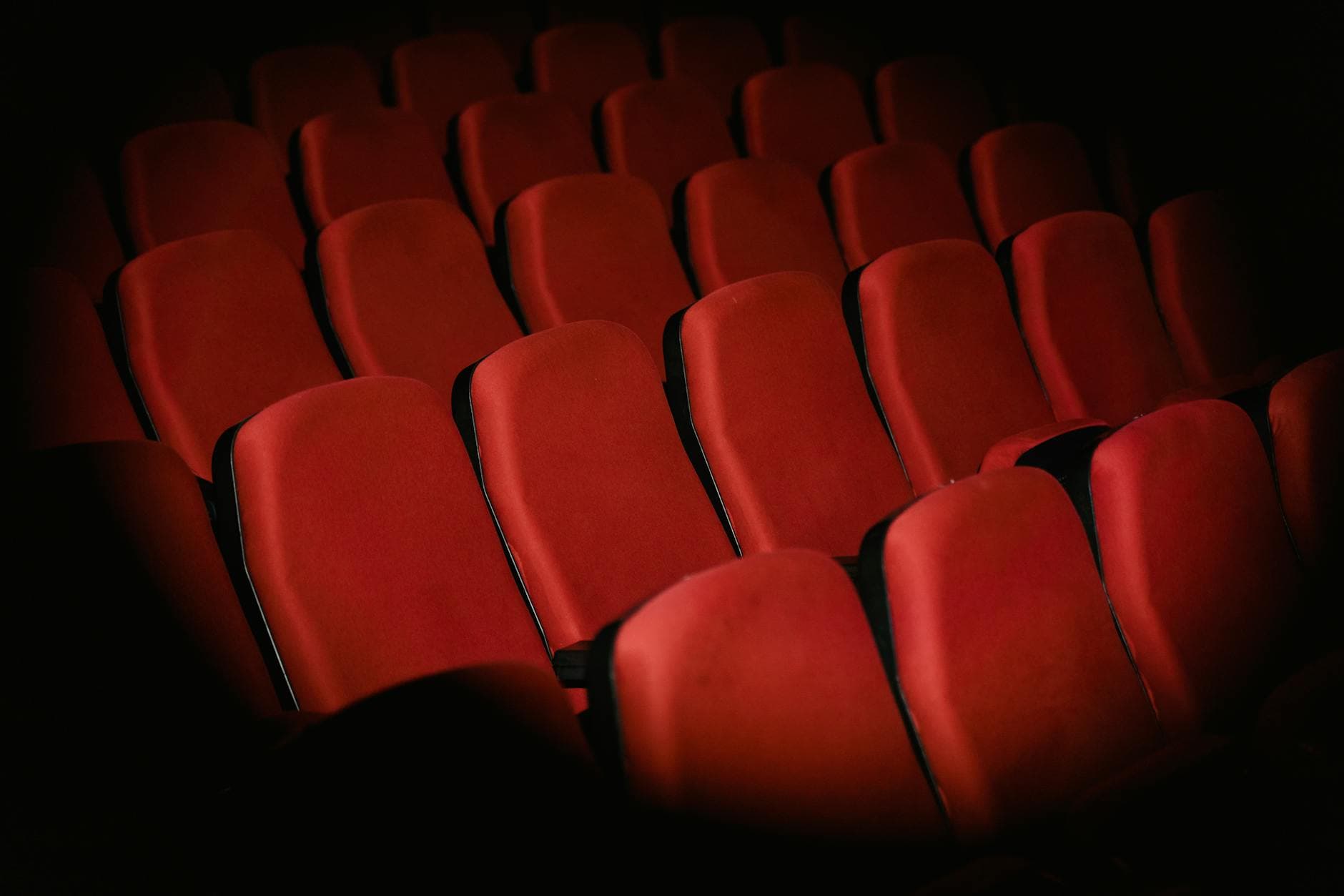 Sala de cine en penumbra con luces de proyección